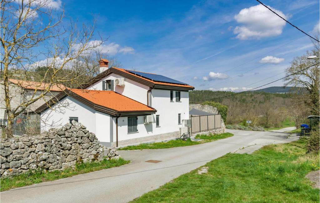 una casa blanca con techo naranja y carretera en Beautiful Home In Divaca With Kitchen, en Divača
