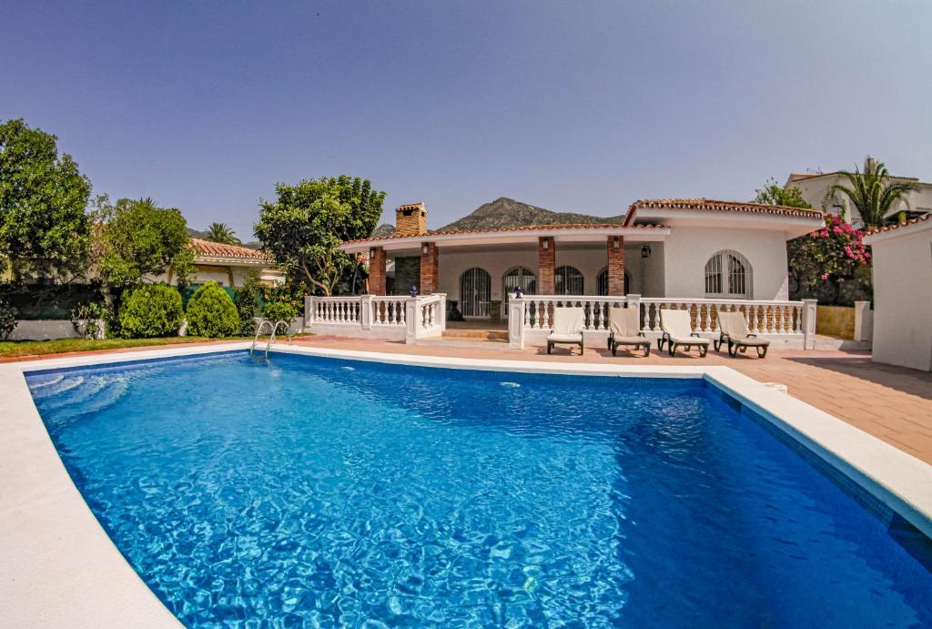 a swimming pool in front of a house at Villa Yanna in Benalmádena