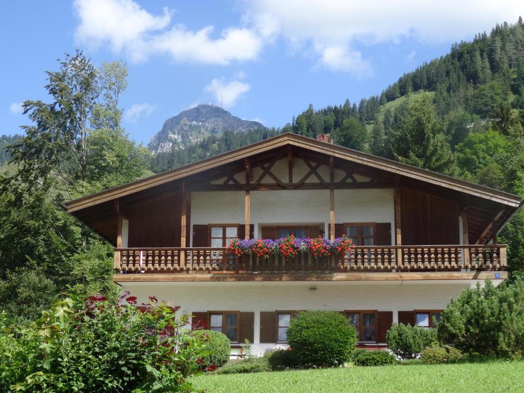 una casa con un balcón con flores. en Ferienwohnungen am Ganglbach en Bayrischzell