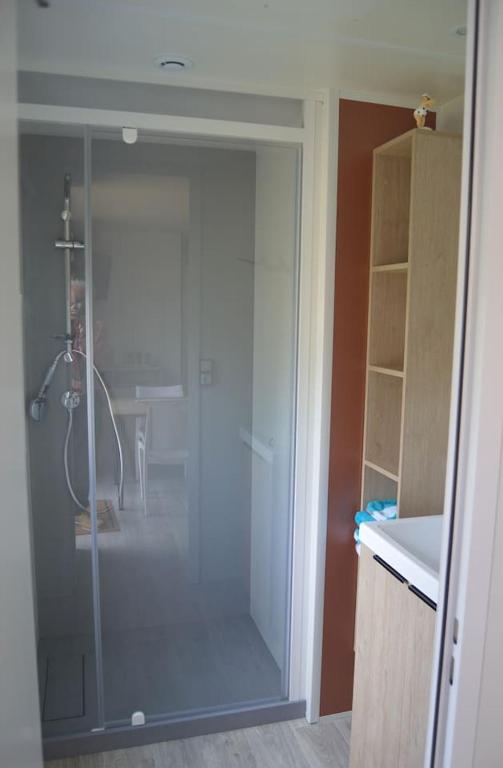 a bathroom with a shower with a glass door at Mobil home neuf en Bretagne sud in Guérande
