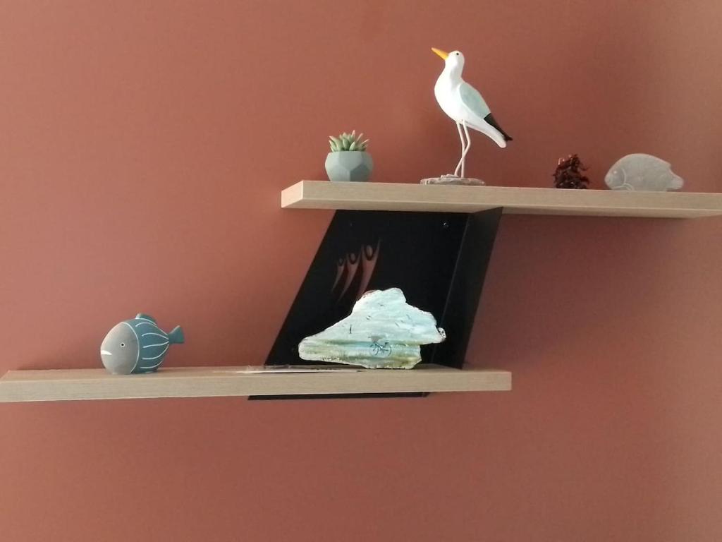 a shelf with a book and a white bird on it at Mobil home neuf en Bretagne sud in Guérande