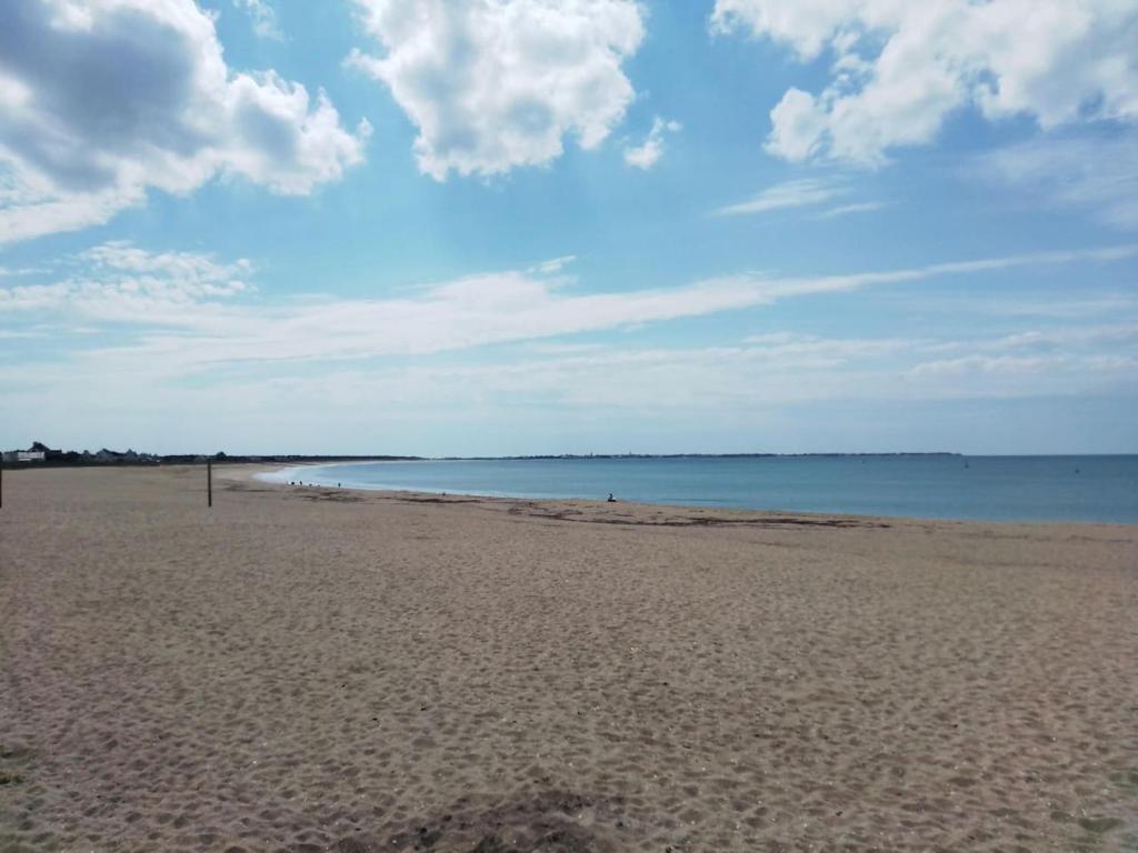 a sandy beach with the ocean in the background at Mobil home neuf en Bretagne sud in Guérande