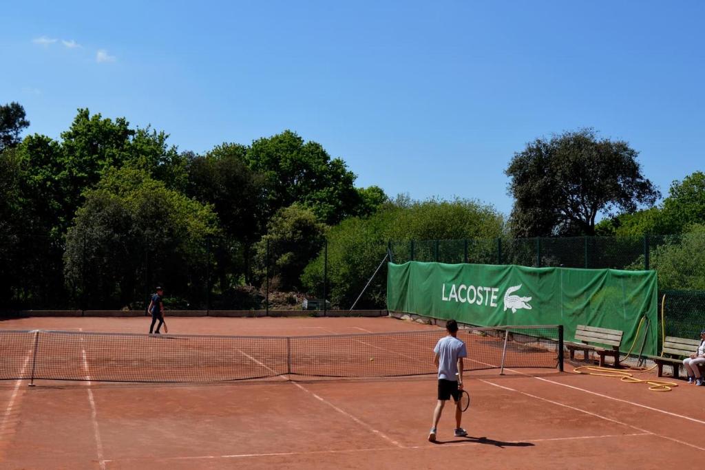 two people playing tennis on a tennis court at Mobil home neuf en Bretagne sud in Guérande