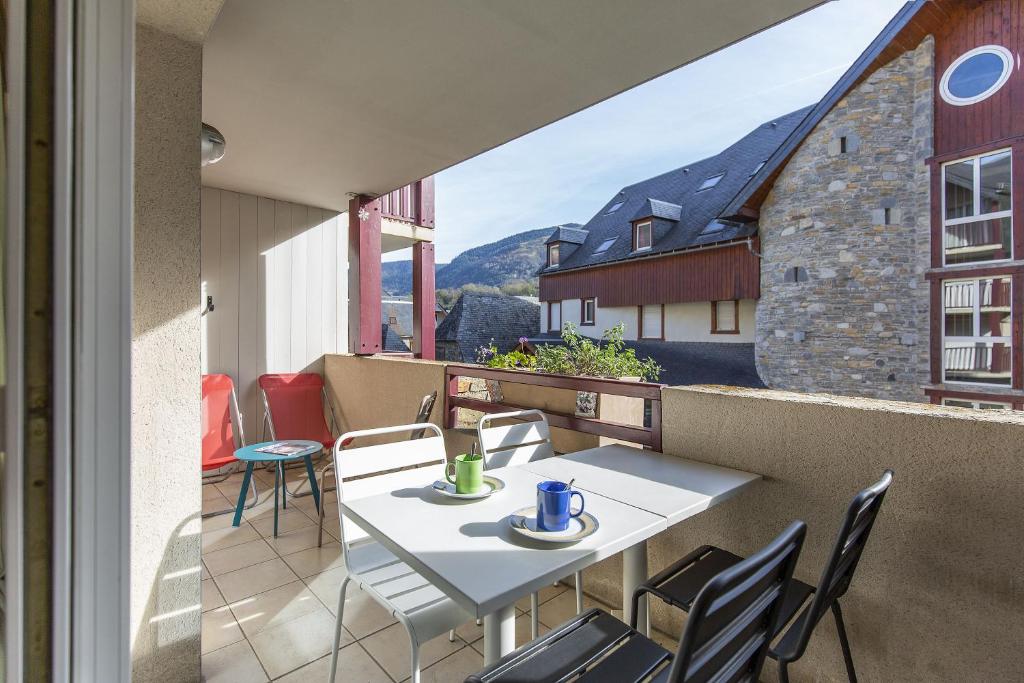 un patio avec une table et des chaises sur un balcon dans l'établissement Appt 4 pers tout équipé, hypercentre village, fibre, garage, linge fourni, à Saint-Lary-Soulan