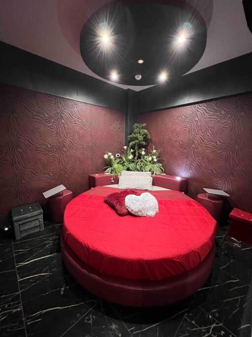 un grande letto rosso in una stanza con pareti rosse di DEVILTHON SUITE NETTUNO a Nettuno
