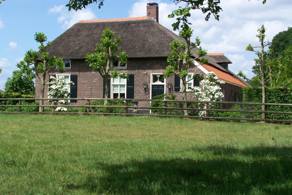 ein Haus mit einem Zaun vor einem Hof in der Unterkunft B&B Farmhouse De Loksheuvel in Overasselt