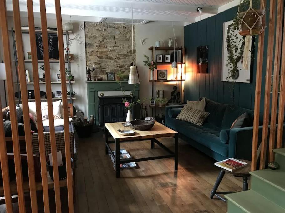 a living room with a blue couch and a table at La maison bleue in Pont-Aven