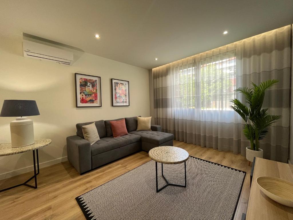 ein Wohnzimmer mit einem Sofa und einem Tisch in der Unterkunft Alta Lisboa Apartment in Lissabon