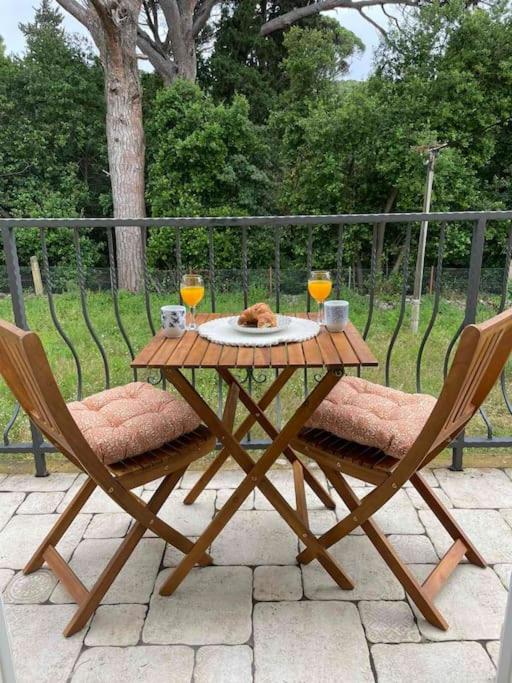 a wooden table with two glasses and a cat sitting on it at Apartman Ezza in Lopud