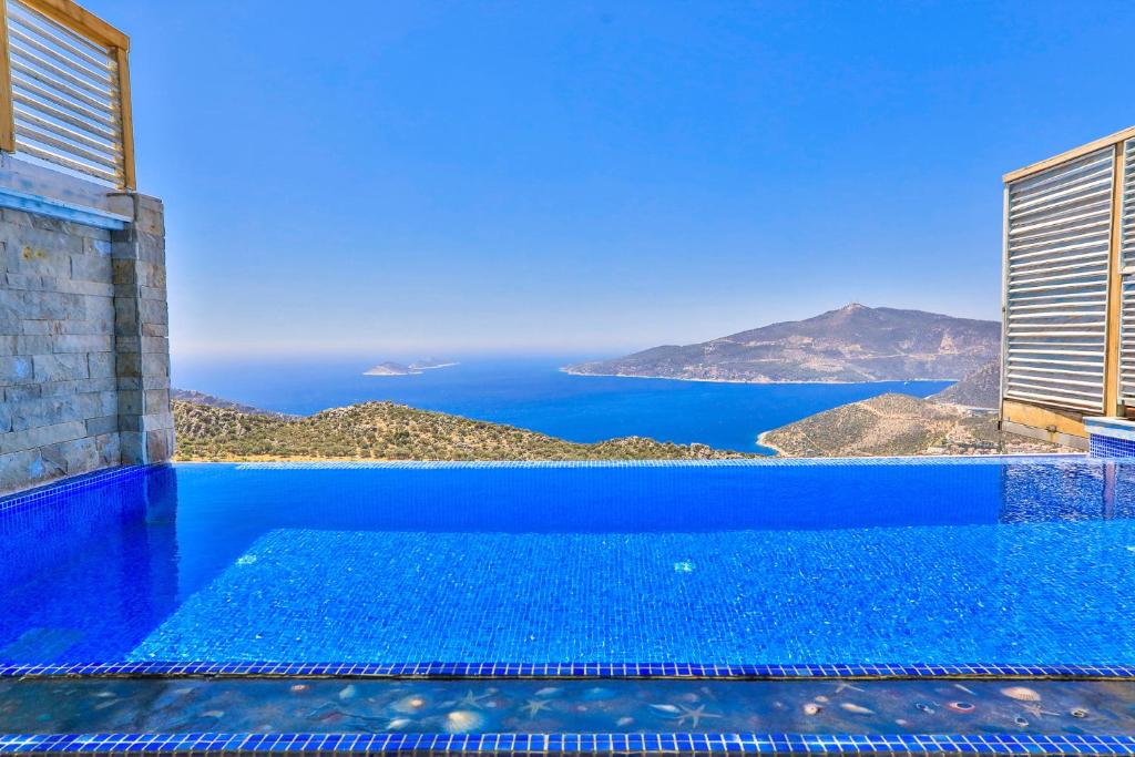 a blue swimming pool with a view of the ocean at Villa Jilda Kalkan in Kalkan