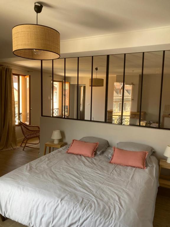 - une chambre avec un grand lit et 2 oreillers roses dans l'établissement Appartement Centre Annecy 100m du lac, à Annecy