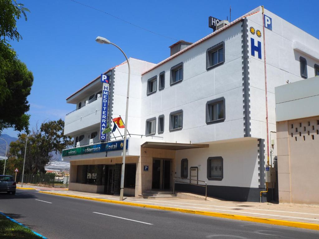 um edifício branco na esquina de uma rua em Hostal Mediterraneo em El Ejido