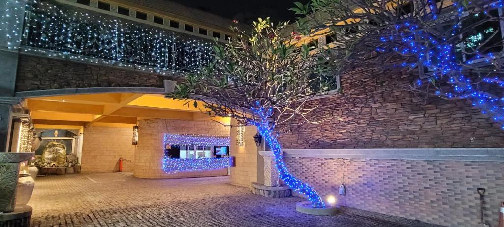 uma árvore decorada com luzes azuis num edifício em Mucha Motel em Kaohsiung