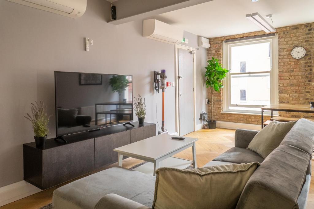 een woonkamer met een bank en een tafel bij City Air Apartments - HATTON GARDEN - GREAT TRANSPORT LINKS in Londen