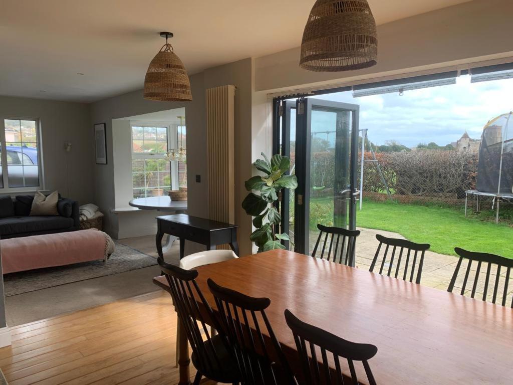 a living room with a dining room table and chairs at Cedar Shade Cottage in Sidmouth