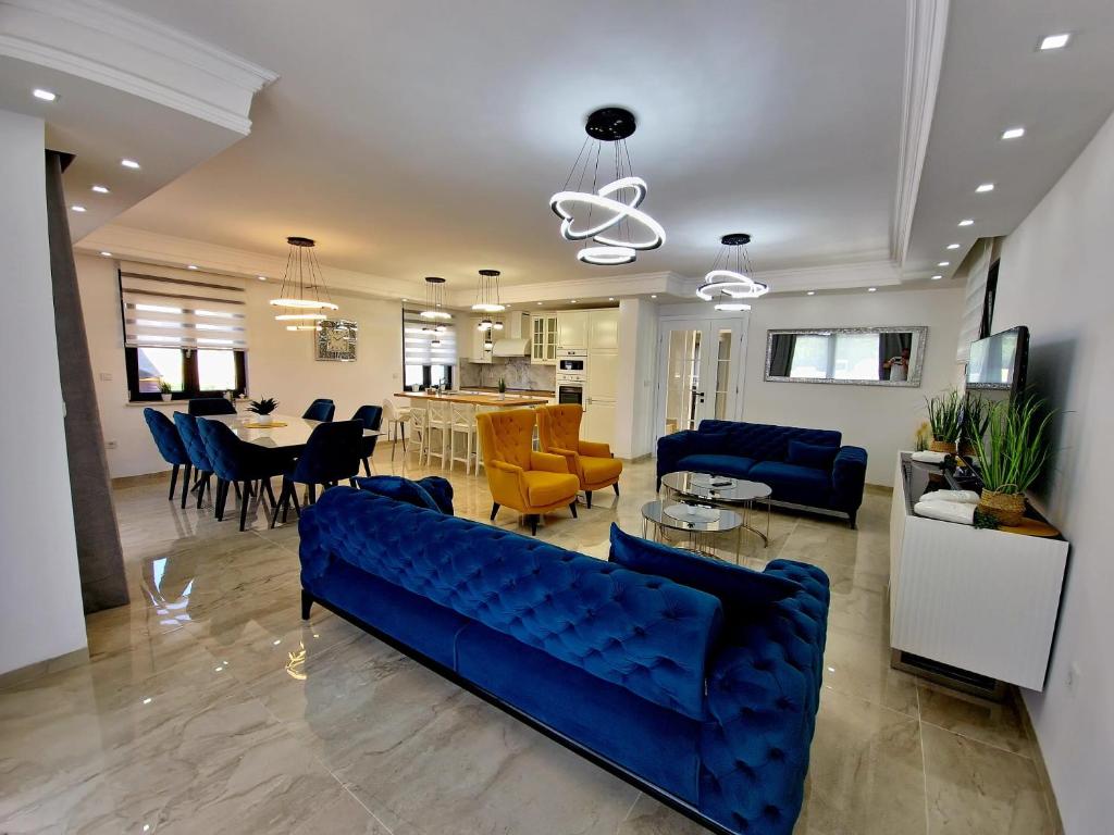 uma sala de estar com um sofá azul e uma sala de jantar em Luxury Villa Laura em Malinska