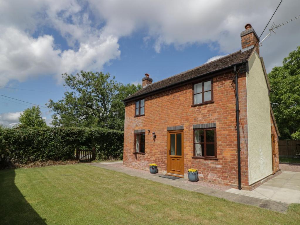 an old brick house with a lawn in front of it at Avoine Cottage in Gloucester