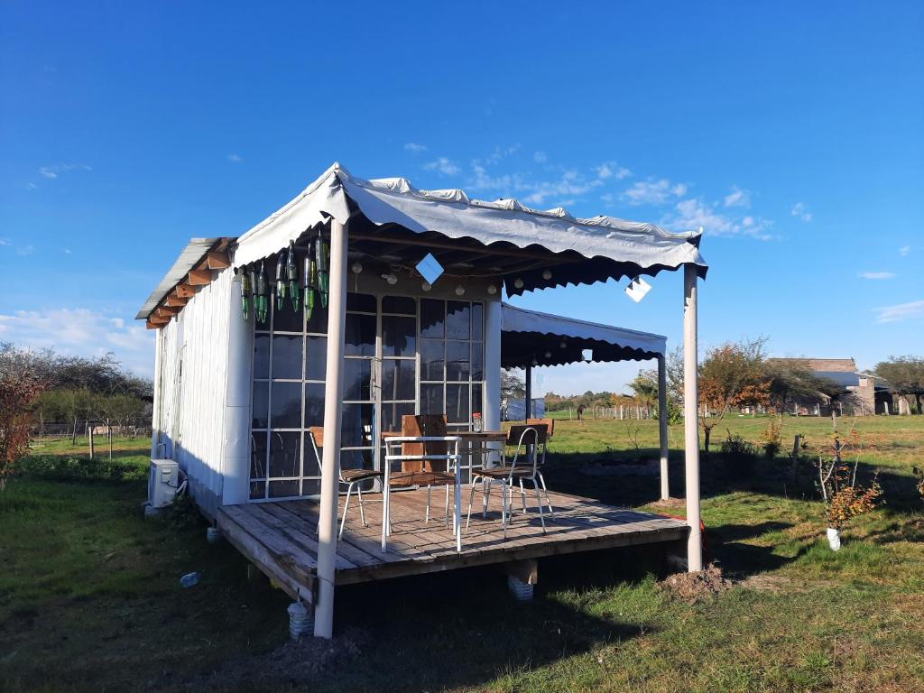 un pequeño cobertizo con mesa y sillas en un campo en Uy MÁGICA Cabaña en entorno Natural único, en Mercedes