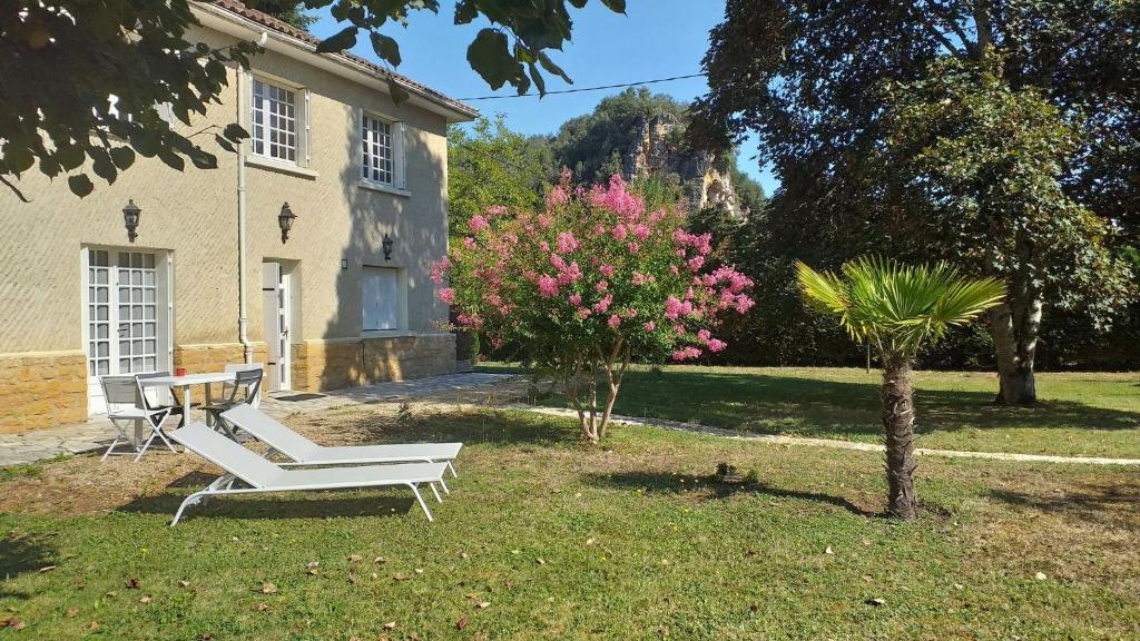 uma mesa e cadeiras no quintal de uma casa em Gîte près de Sarlat avec jardin et salon de massages em Carsac-Aillac