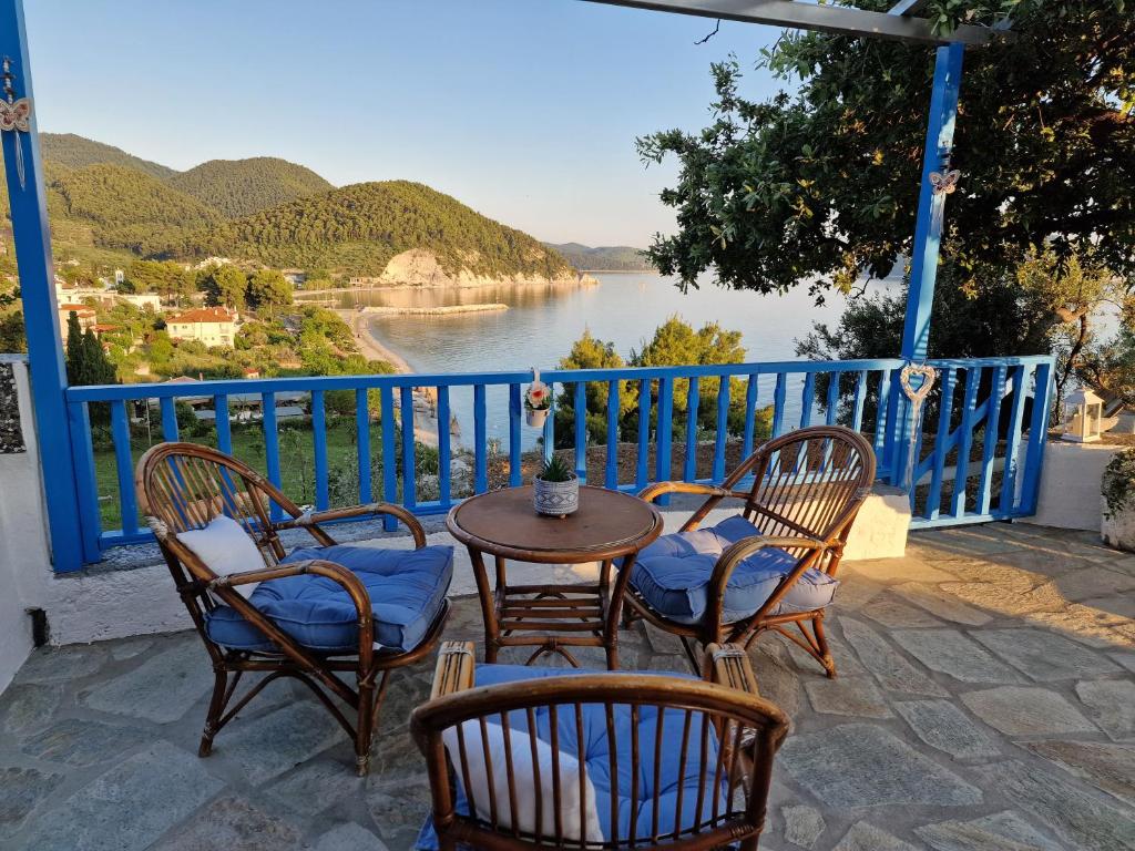 d'une terrasse avec des chaises et une table offrant une vue sur l'eau. dans l'établissement Crystal Villa, à Skopelos