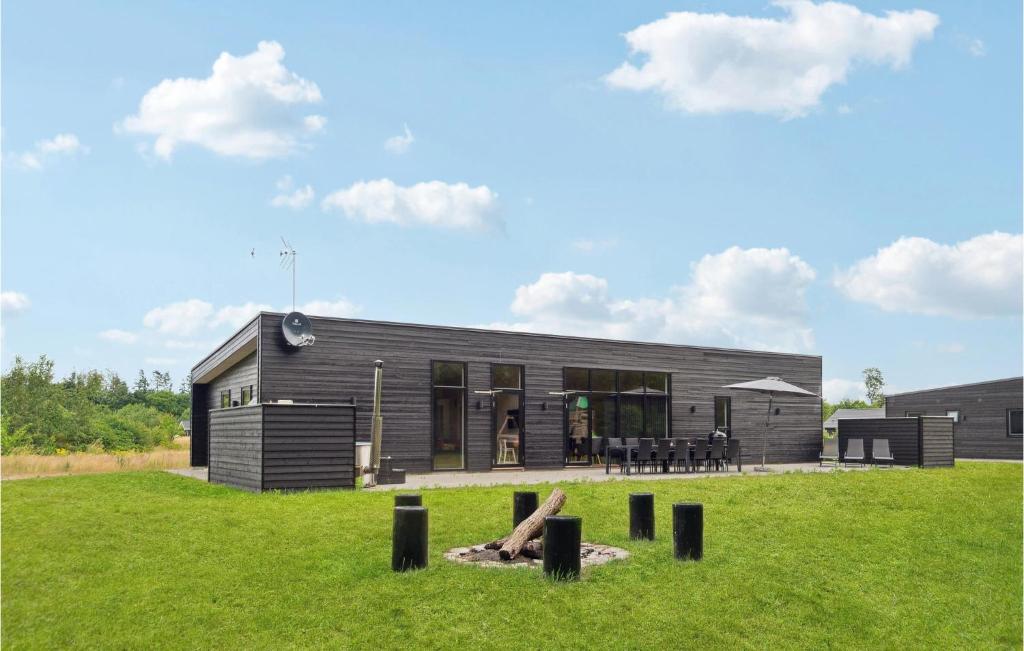a black house with a lawn in front of it at 5 Bedroom Nice Home In Glesborg in Glesborg