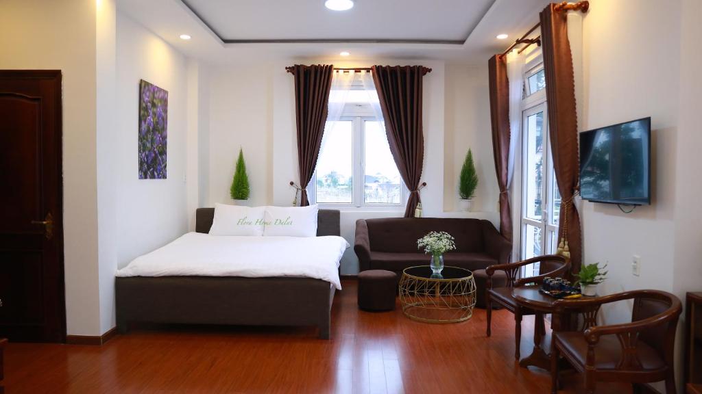 大叻的住宿－FLORA HOME DALAT，客厅配有床和沙发