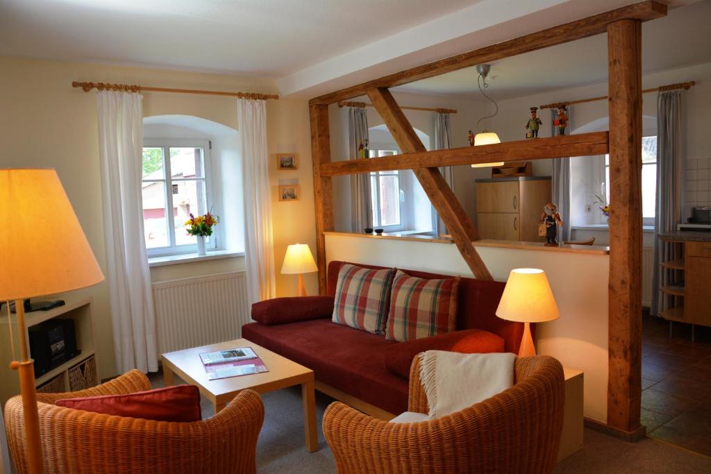 a living room with a red couch and chairs at Verlegerhaus Seiffen in Seiffen