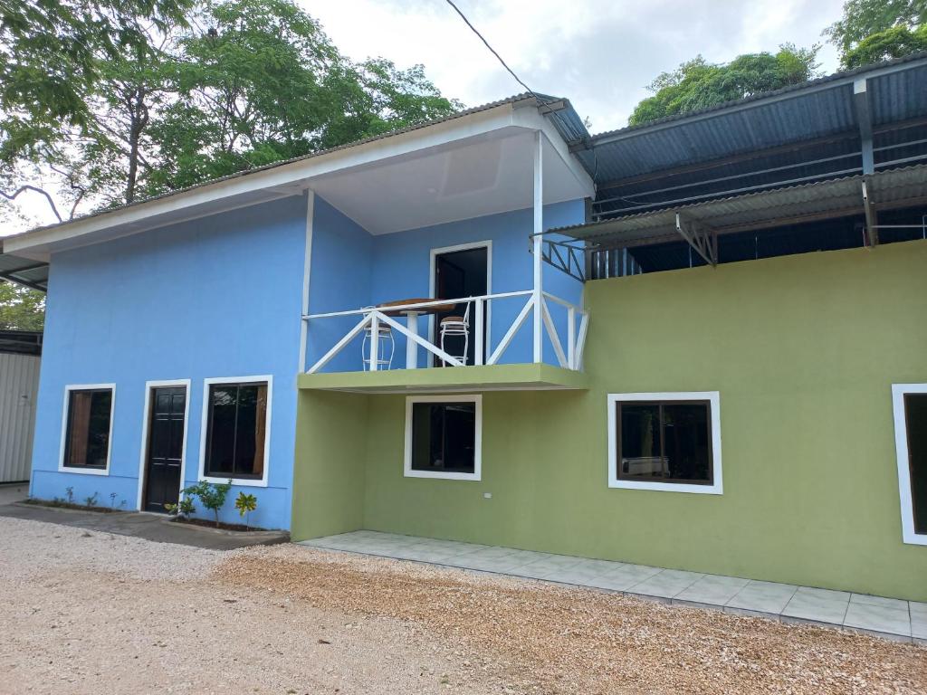 une maison bleue et verte avec un balcon dans l'établissement Casa Hortensia, à Nicoya