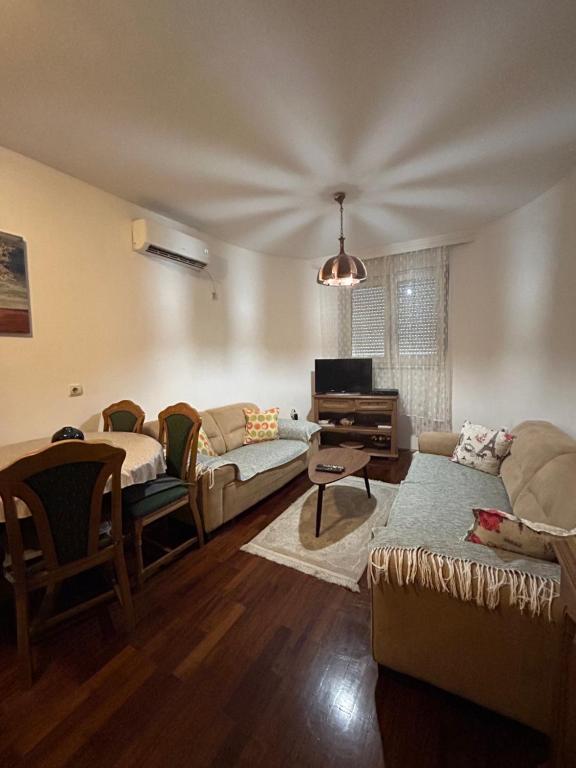 a living room with a couch and a piano at Apartment Sara in Podgorica