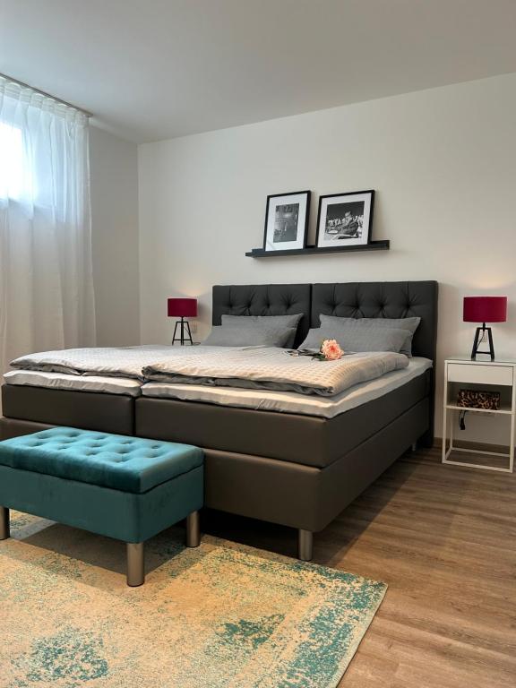 1 dormitorio con 1 cama grande y 1 reposapiés azul en Premium Ferienwohnung im Herzen der Kurstadt, en Bad Neuenahr-Ahrweiler