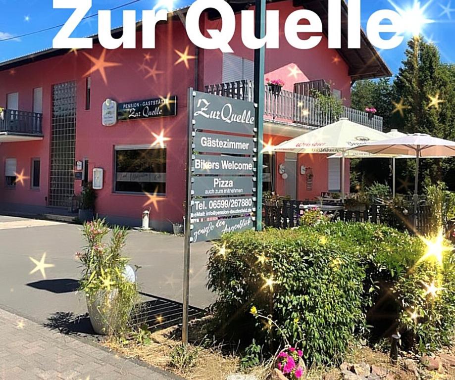 a restaurant with a sign in front of a building at Pension zur Quelle in Deudesfeld