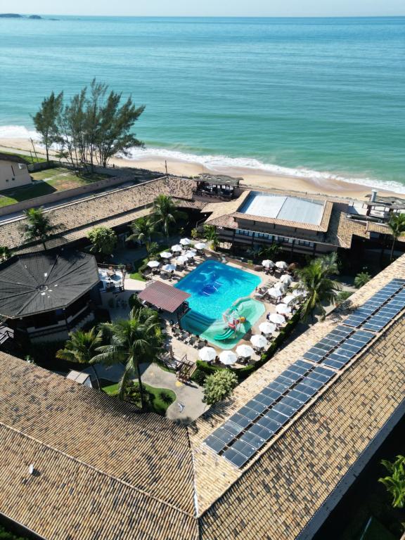 uma vista aérea de um resort com piscina e praia em Hotel Vilarejo Praia em Rio das Ostras