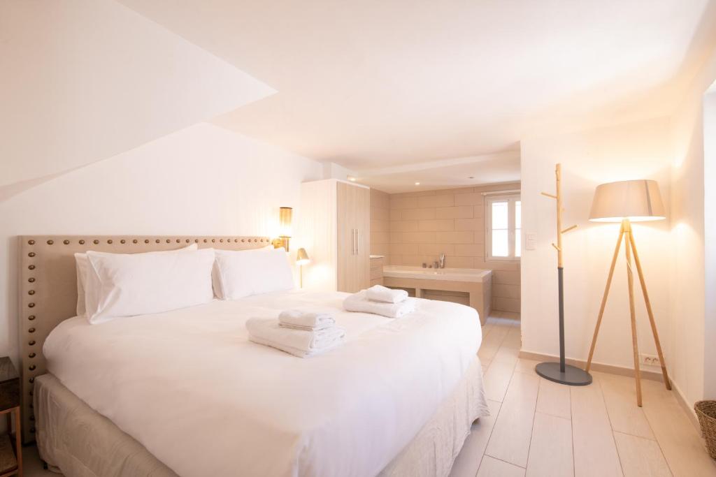 Un dormitorio blanco con una gran cama blanca y una lámpara en Pick A Flat&#39;s Apartment in Saint-Tropez- Rue du Portail Neuf, en Saint-Tropez
