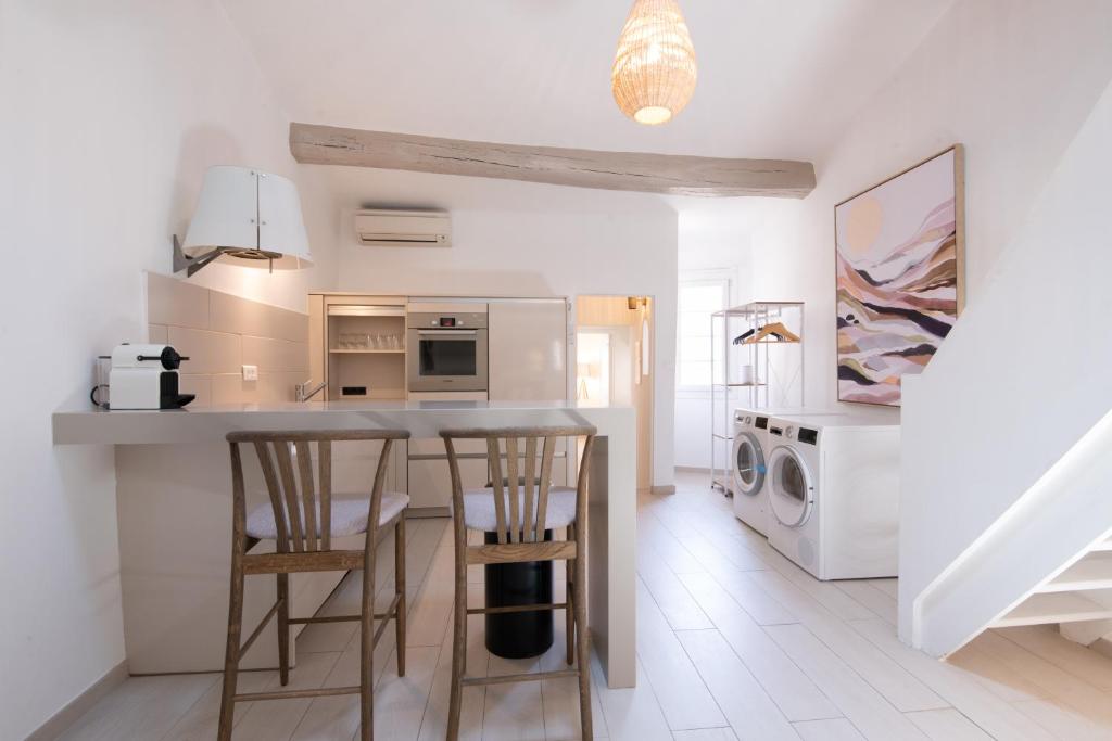 cocina con barra y 2 taburetes en Pick A Flat&#39;s Apartment in Saint-Tropez- Rue du Portail Neuf, en Saint-Tropez