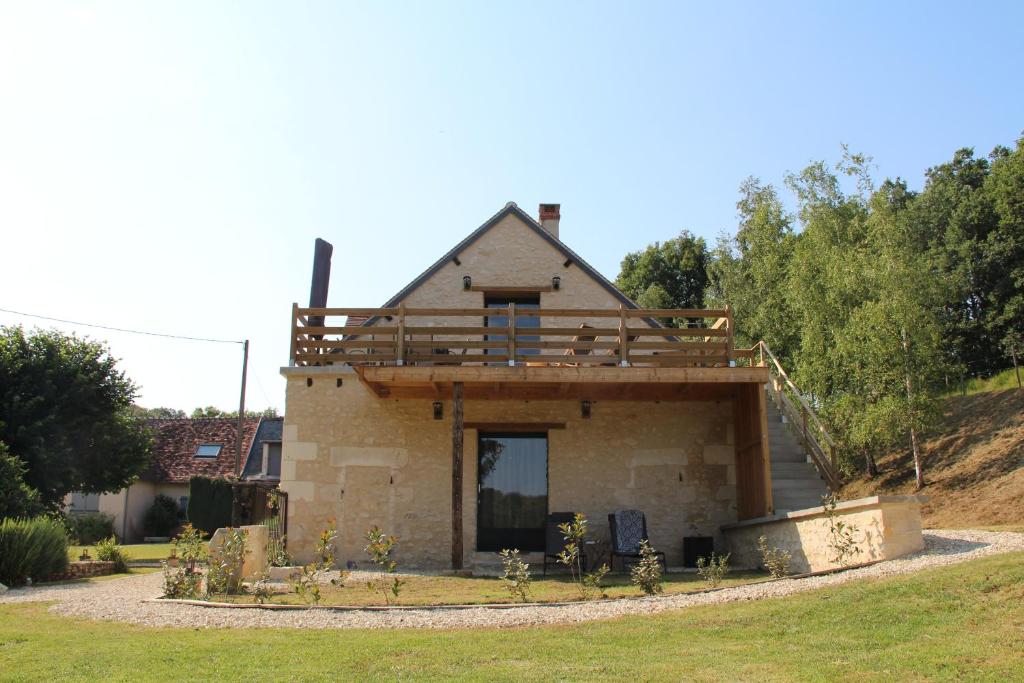 a house with a deck on top of it at Gîte de la Forge, le Grenier in Fléré-la-Rivière