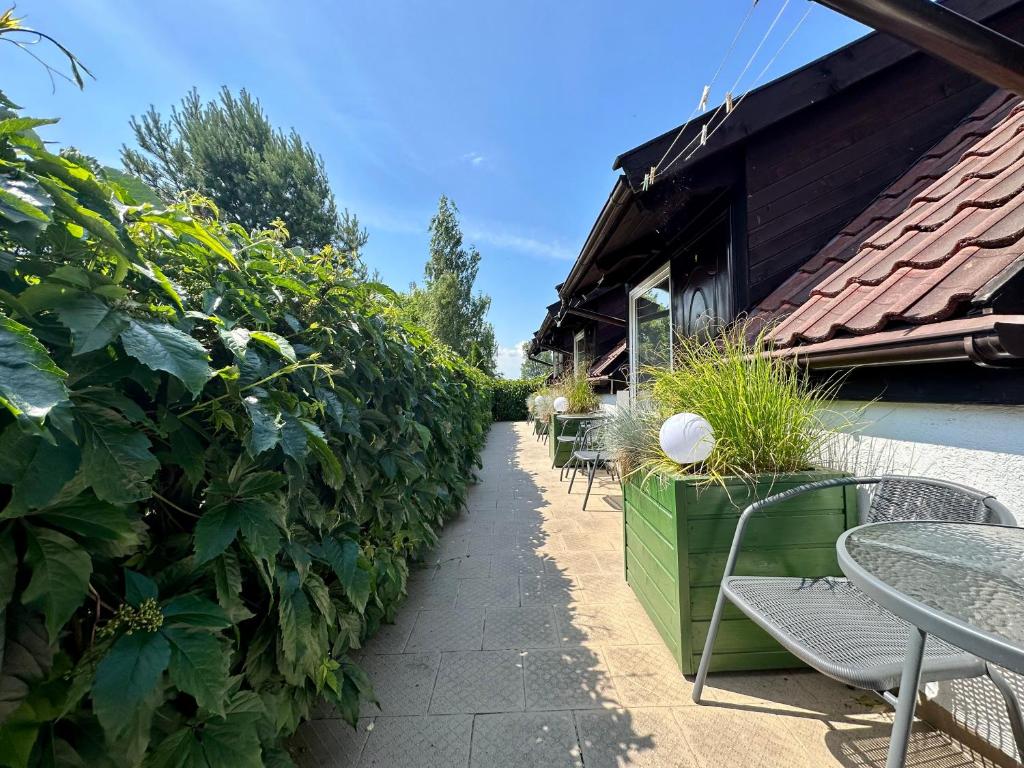 a patio with tables and chairs next to a building at Leniwy Kot in Stegna