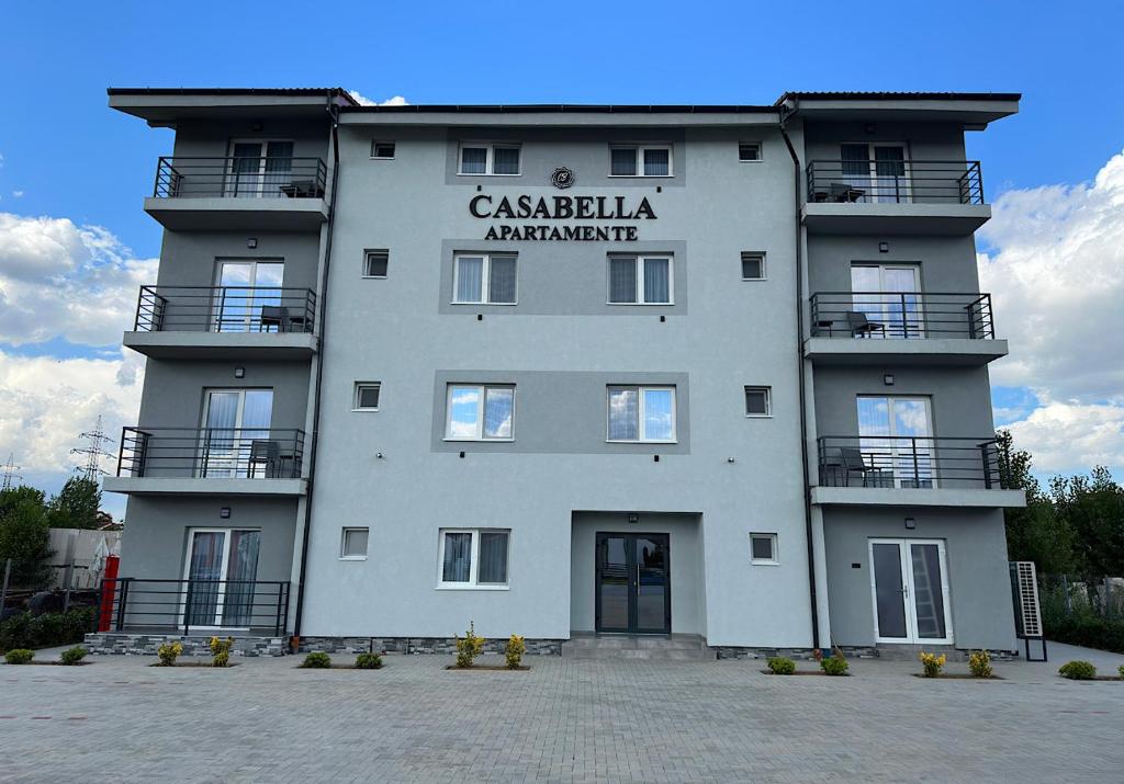 a large white building with a sign on it at Apartamente CasaBella in Baile Felix