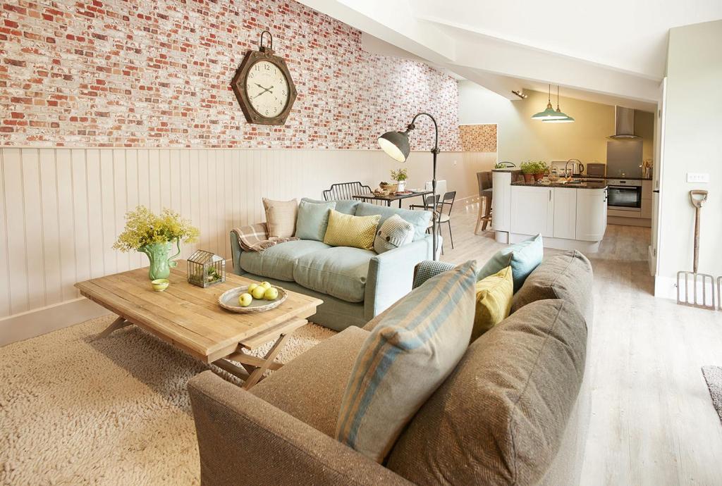 a living room with a couch and a table at The Gardener's Bothy in Shifnal