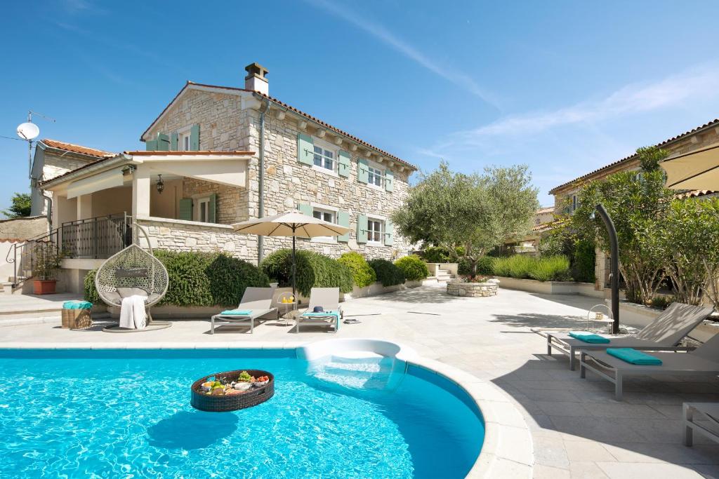 a swimming pool in front of a house at Residence Pietre d'Istria - with private service in Burići