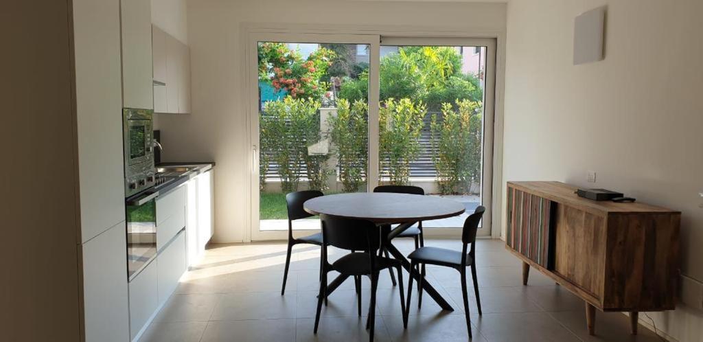 een keuken met een tafel en stoelen en een raam bij Claudia Apartment Peschiera in Peschiera del Garda