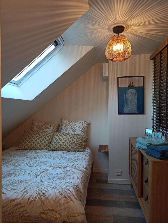 a bedroom with a bed and a skylight at Ty Calouenn, la plage à pied in Le Pouldu
