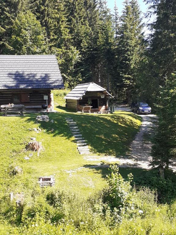 a cabin in the woods with a car parked next to it at Brunarica na Goreljeku in Bohinj
