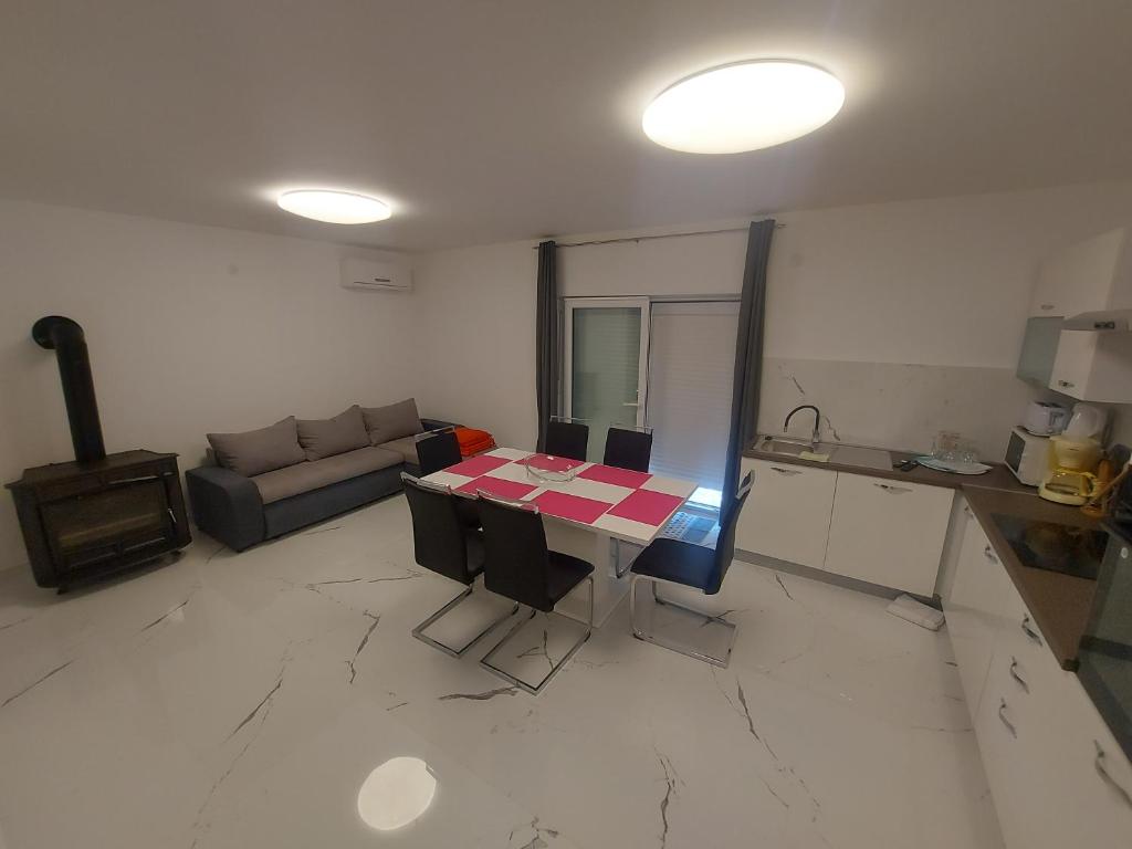 a kitchen and living room with a table and a couch at Apartments Novak in Klenovica