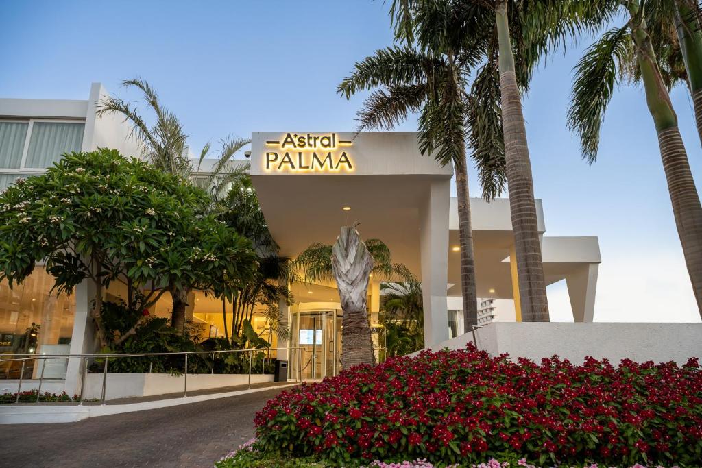 un edificio con palmeras delante en Astral Palma Hotel en Eilat