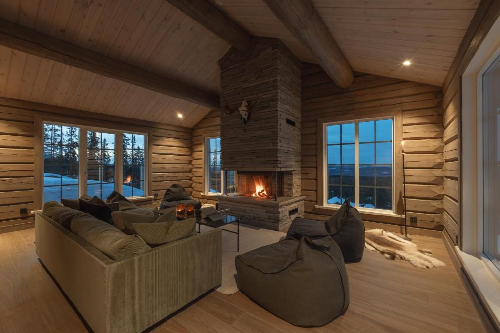 a living room with a fireplace in a log cabin at Fjällparadiset Lindvallen in Sälen