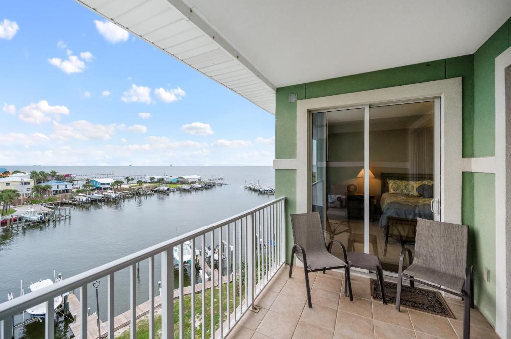 balcón con sillas y vistas al agua en Navy Cove 1405 en Gulf Shores