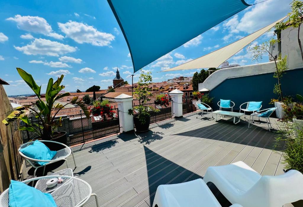 een patio met witte stoelen en een parasol bij Urban Sea Hotel Atocha 113 in Madrid