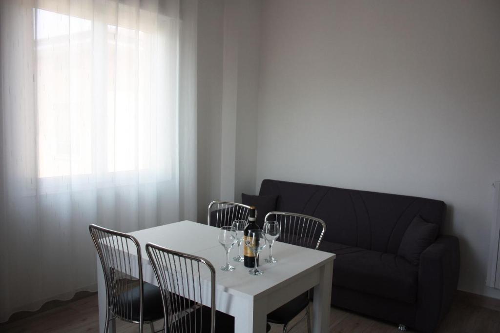 sala de estar con mesa, sillas y sofá en [Stazione] - Casa privata con veranda, en Romano di Lombardia