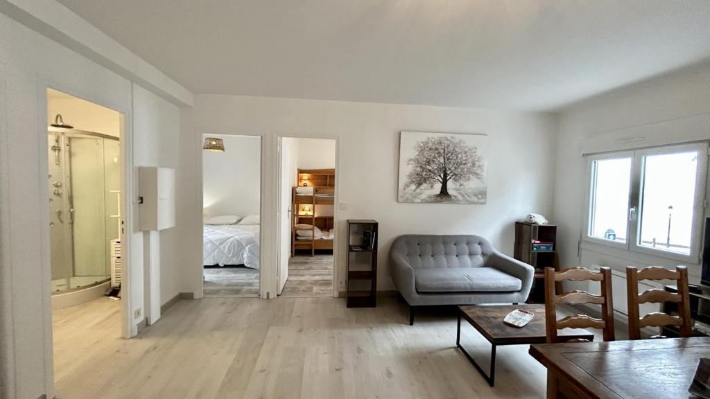 a living room with a couch and a bedroom at L'Appart de nos 2 vies in Le Crotoy