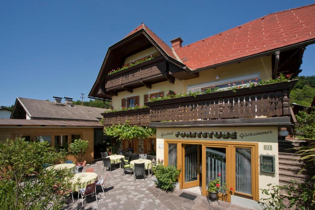 a building with a patio with tables and chairs at Gasthof Forststube in Velden am Wörthersee